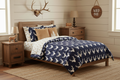 Navy buck woodland comforter with white deer silhouettes on twin bed in little boy's rustic woodland room with fawn minky accents